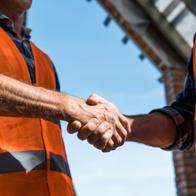 cropped-view-of-men-shaking-hands-against-blue-sky-2021-09-21-23-41-33-utc-1.jpg